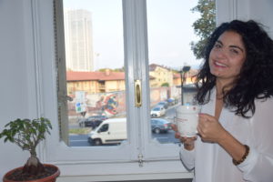 social media manager con una tazza in mano di fronte ad una finestra